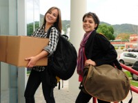 Student with cardboard box  moving in to the campus